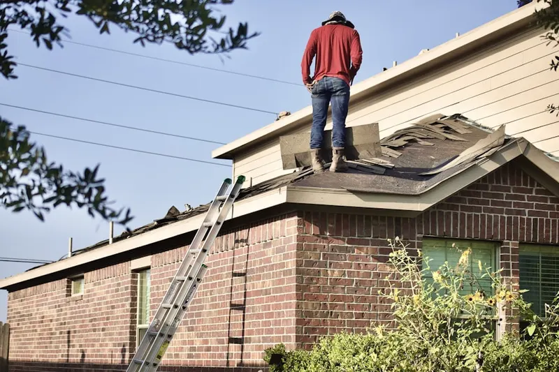 Professional roofer working on a residential roof in Lawrence Corner